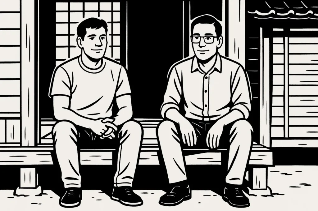 古民家の縁側に座って談笑する男性2人・